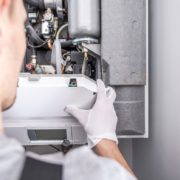 Close up of a contractor repairing central heating furnace system.