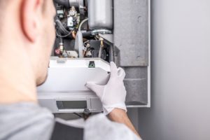 Close up of a contractor repairing central heating furnace system.