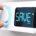 Hand turning a thermostat knob to increase savings by decreasing energy consumption. Composite image between a hand photography and a 3D background.